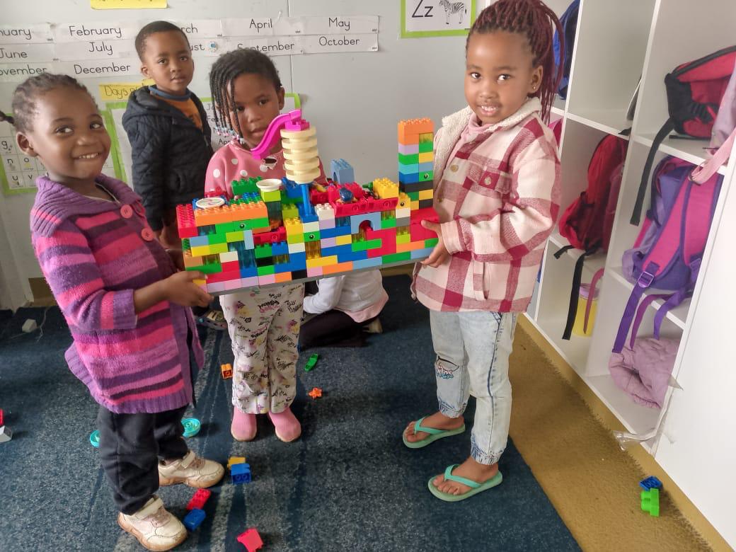 Children showing off the castle they built with blocks